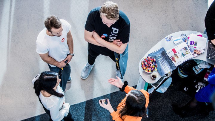 Bild tagen uppifrån på studenter i samtal med personer från ett företag.