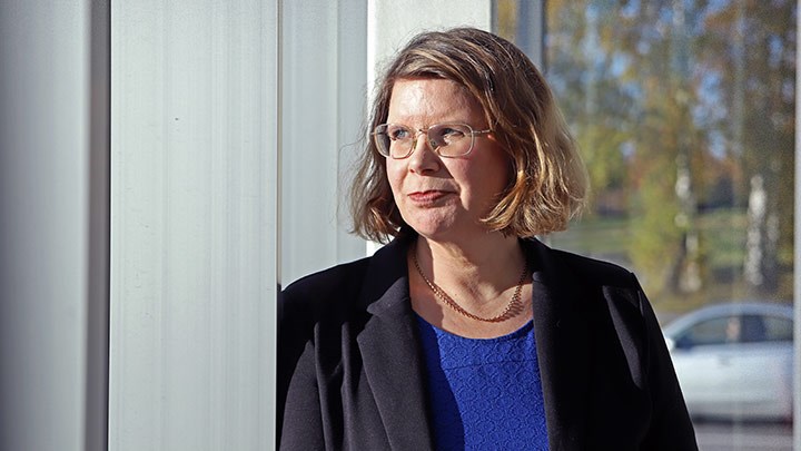 Arita Holmberg står vid ett fönster. 