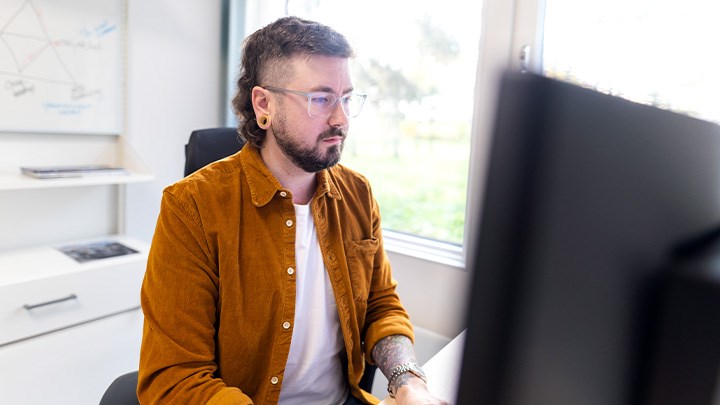 Photo of a person sitting by a computer.