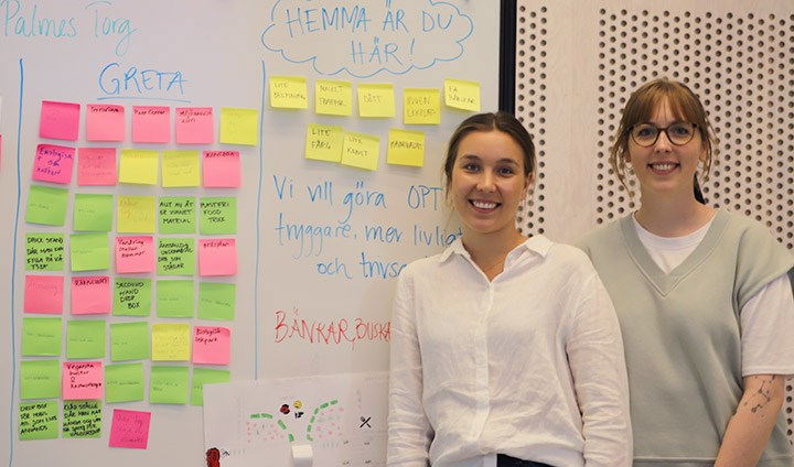 Alexandra Bencze och Matilda Eklund står vid en whiteboard med post-it lappar.