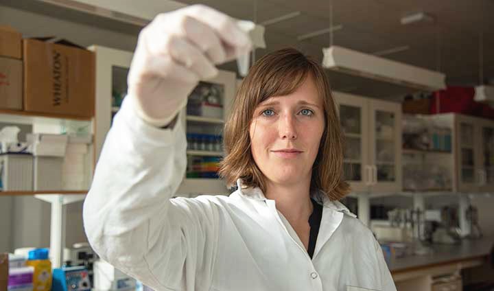 Julia Rode looking at a test tube.