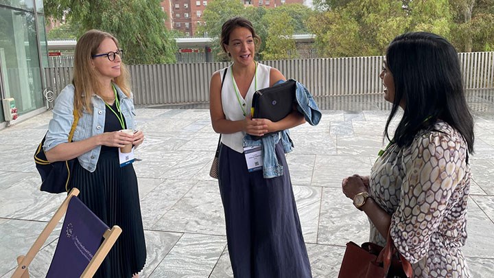 Three women standing in a circle talking