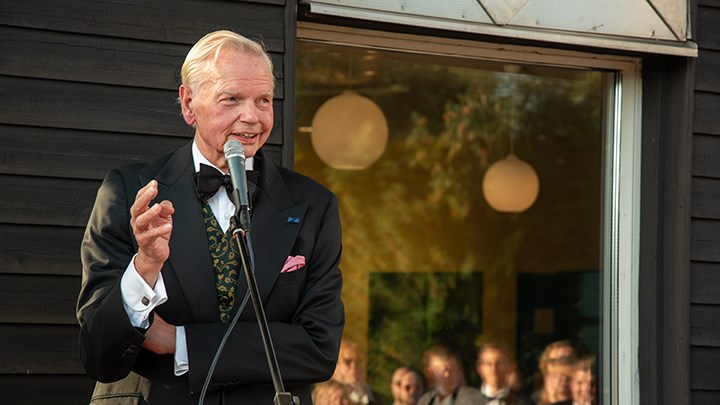 Carl-Jan Granqvist vid en mikrofon framför Måltidens hus fasad.