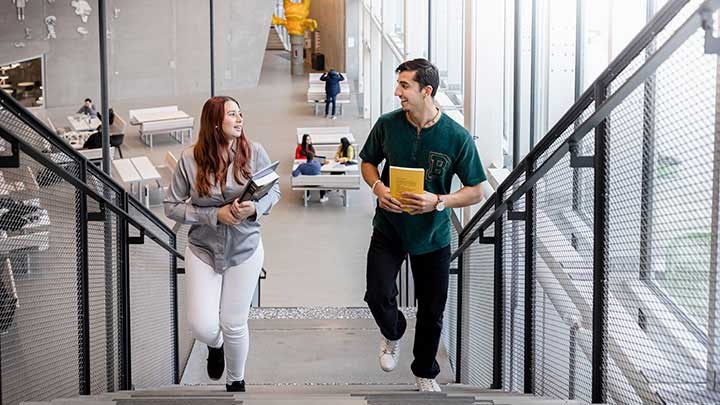 Två studenter som går i en trappa.