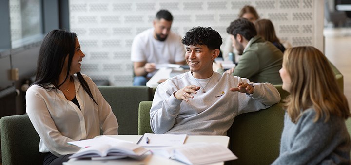 Tre studenter sitter och pratar.