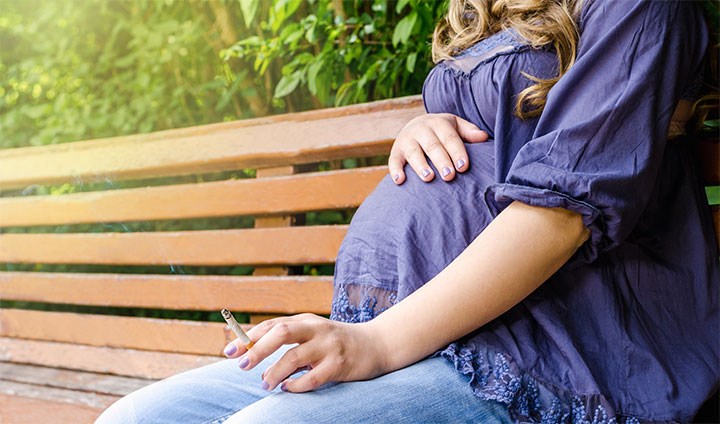 Bilden föreställer en gravid kvinna som röker