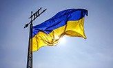 En blågul flagga från Ukraina mot en blå himmel.