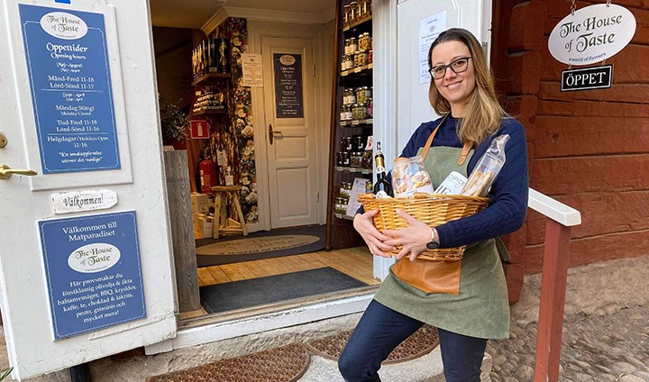 Dominique Prahl Fernandes har en korg med delikatesser i famnen och står utanför sin praktikplats, The House of Taste.