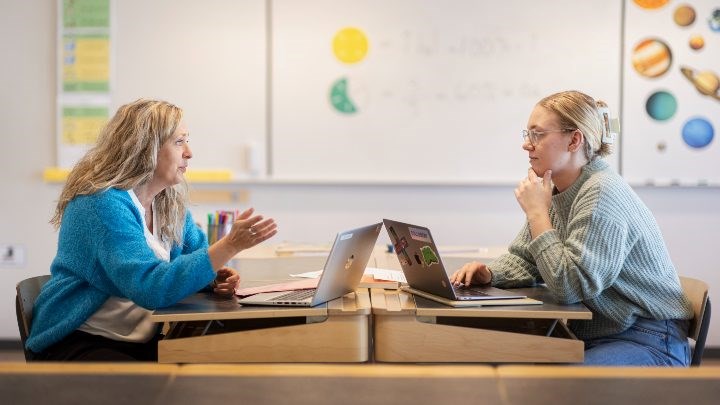 Lärare och elev vid bord i klassrum