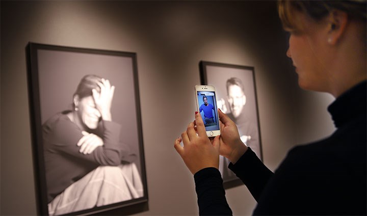 A student looks at portraits of Alumni.