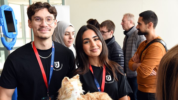 Alexander Åskag och Ilaaf Ramzi är två av studentkonsulterna som extrajobbar som värdar under AI-dagarna på Örebro universitet. På bilden hjälper de till vid robotutställningen, där det bland annat finnas robotkatter: ”Det är väldigt intressant med AI”.