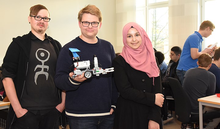 Andreas Persson, Max Niia och Ateka Al-Nuaimi i en föreläsningssal med roboten i lego.