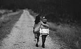 Två barn går längs en grusväg.