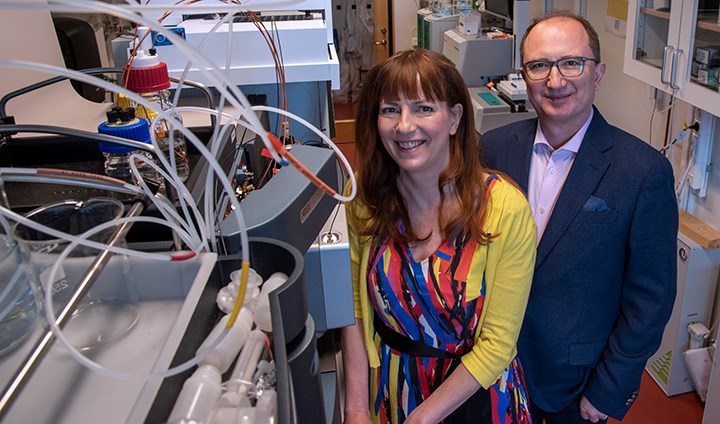 Tuulia Hyötyläinen och Matej Orešič står bredvid en maskin i ett laboratorium.