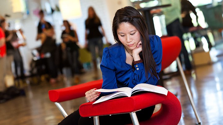 Foto på en student som sitter och läser.