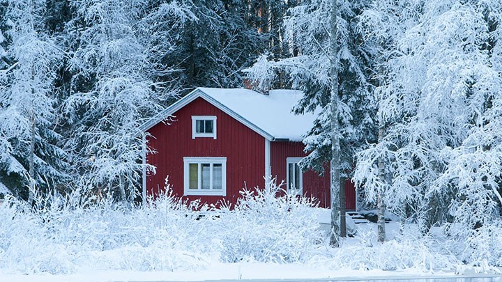 En röd stuga i ett vinterlandskap.