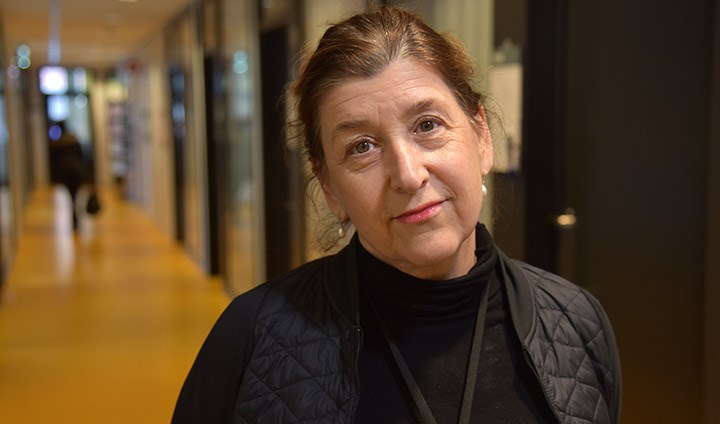 Yvonne Freund-Levi står i en korridor och tittar in i kameran.