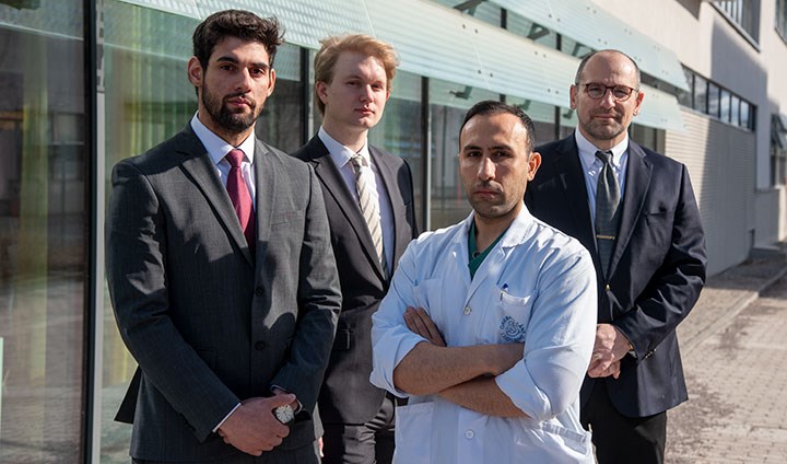 En gruppbild på doktoranderna Ahamad Mohammad Ismail, Maximillian Forssten och Jannis Iosnnidis.Framför de kostymklädda doktoranderna står Shahin Mohseni i vit läkarrock.