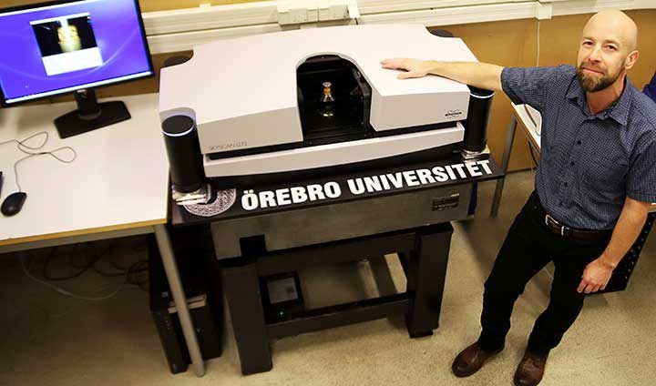 Patrik Karlsson bredvid CT-skannern på Örebro universitet.