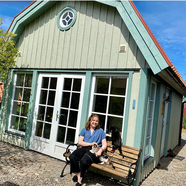 Johanna Österling med katterna Sven och Greta utanför attefallshuset.  