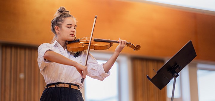 En kvinnlig student spelar fiol.