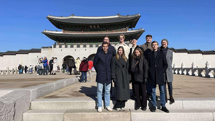 A group of people posing for a photo in front of a building.