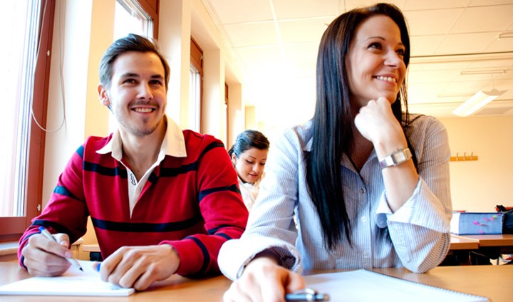 A man and a woman are sitting together and studying. 