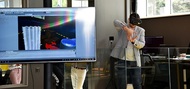 En person med VR-glasögon på sig i ett robotlabb.