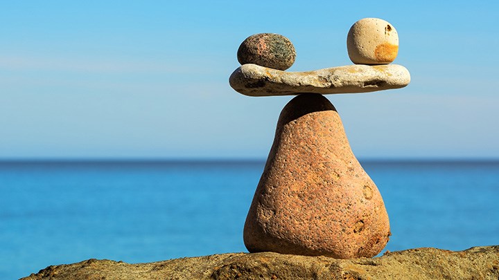 Stones in different shapes form a tower where two stones are balanced.