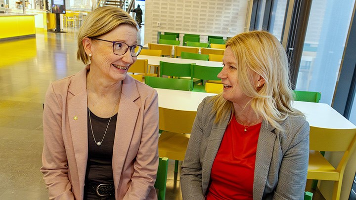 Elina Mäki-Torkko och Karin Blomberg sitting indoors talking.