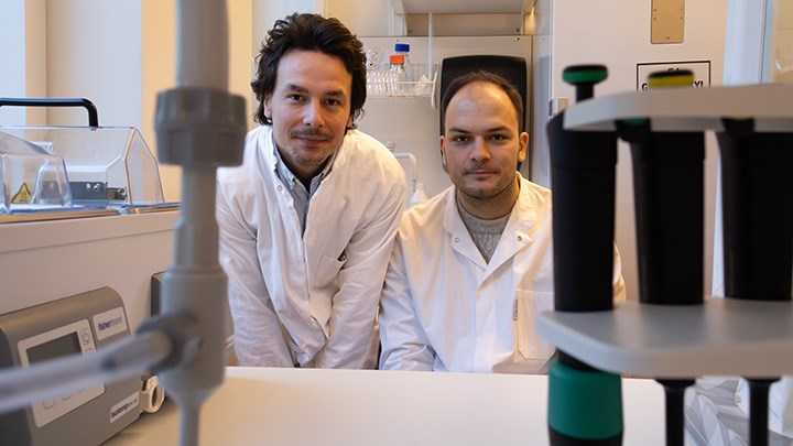 Two people wearing white lab coats.