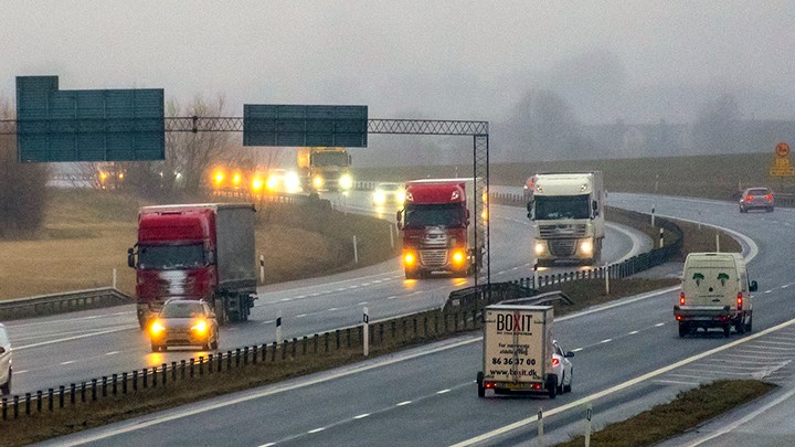 Rad av lastbilar på en motorväg i dis