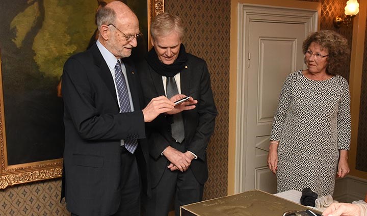 Michael W. Young and Michael Rosbash takes a photo of theirs handprints.