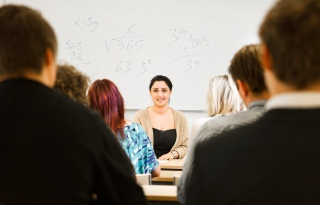 Student som talar inför andra studenter i klassrum