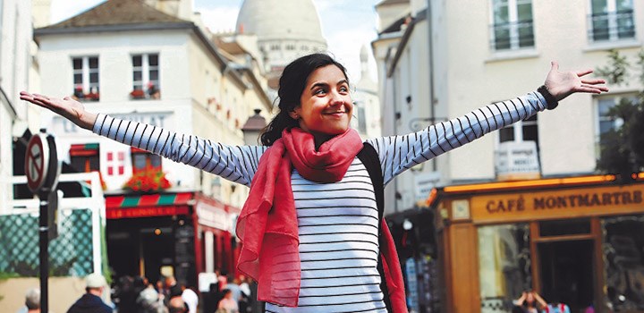 A photo of a travelling alumnae with arms open wide